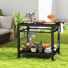 an outdoor bar cart with drinks on it in the grass next to a couch and potted plant