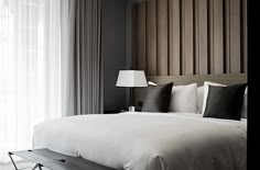 a large bed with white sheets and pillows