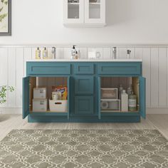 a bathroom with a blue cabinet and rug on the floor in front of white walls