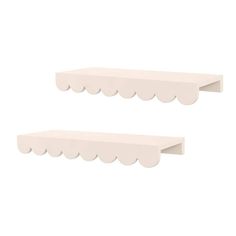 two white shelfs with scalloped edges against a white background, one is empty