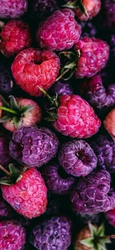 raspberries and other fruits are piled together