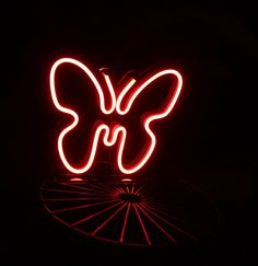 a red neon sign with a butterfly on it