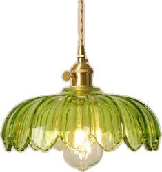 a green glass light hanging from a ceiling