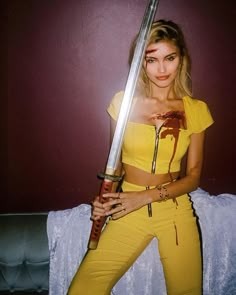 a woman in yellow holding a large knife