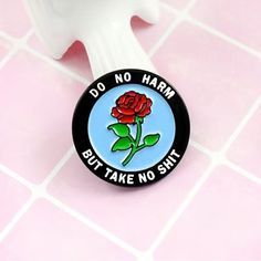 a pin with a rose on it sitting on a tile floor