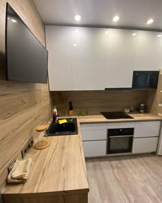 a kitchen with white cabinets and wooden counter tops is shown in this image, there are no people or objects on the counter