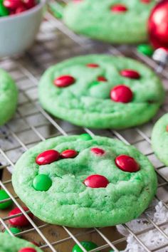 green cookies with red and green candies on a cooling rack