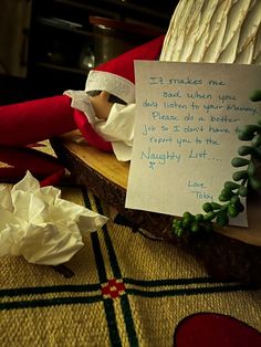 an elf's hand holding a note on top of a table