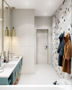 a bathroom with two sinks and a coat hanging on the wall in front of it