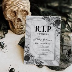 a wedding card sitting on top of a table next to a fake skull and spider