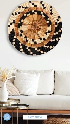 a living room with a white couch and wooden wall art