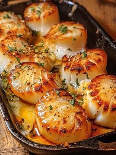 some scallops are sitting in a pan on a wooden table and ready to be eaten