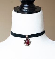 This Victorian inspired choker is made from black velvet ribbon and antique bronze filigree pendant housing a dark red glass cabochon. - The choker measures 12 inches/30.5cm in length and 0.4 inches/10mm wide - The pendant is approximately 1 inch long and 0.75 inch wide - The choker closes with a lobster claw clasp at the back - One size fits most (for a neck of about 12.5 inches). there is a 2 inch extension chain at the back to accommodate larger neck sizes SHIPPING: Default shipping is by reg Black Choker With Pendant, Red Acssesories Aesthetic, Gothic Pendant Necklace, Black Vintage Jewelry, Vintage Jeweled Choker As Gift, Vintage Jeweled Choker Gift, Adjustable Red Cabochon Jewelry, Vintage Red Choker For Party, Red Adjustable Classic Jewelry