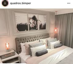 there is a bed with pillows on it and pictures above the headboard in this bedroom