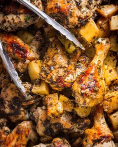 chicken and potatoes in a pan with tongs