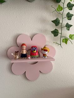 three figurines are sitting on a shelf in the shape of a flower and two cats