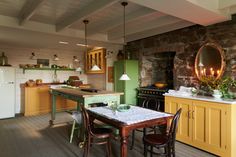 a kitchen with green walls and yellow cabinets is pictured in this image, there are two chairs at the table