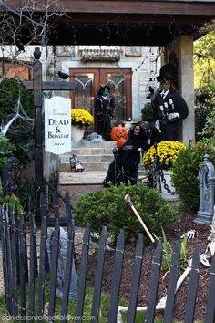 a house decorated for halloween with skeletons and pumpkins