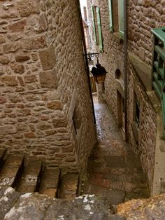 an alley way with stone walls and stairs