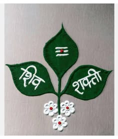 two green leaves with white flowers and the words india written in red on them, sitting next to each other