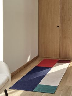 a white chair sitting next to a wooden closet