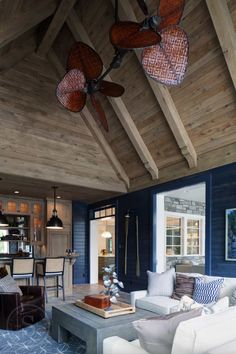 a living room filled with furniture and a ceiling fan in the middle of an open floor plan