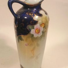 a blue and white vase with flowers painted on it