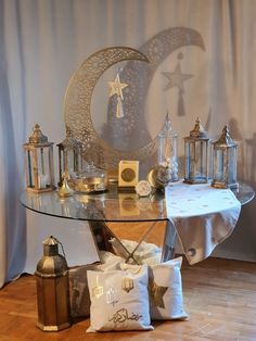 a glass table topped with lots of items on top of a hard wood floor next to a curtain