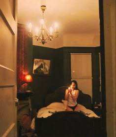 a woman is taking a selfie in her bedroom while sitting on the bed and looking into the mirror