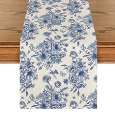 a blue and white table runner with flowers on it