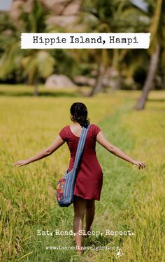 a woman in a red dress is walking through tall grass with her arms spread out