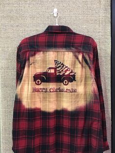 a red and black plaid shirt with a christmas tree on the truck that says merry christmas