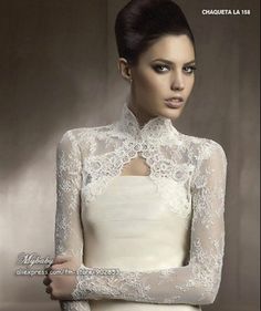 a woman in a white dress with long sleeves and lace on her arms, posing for the camera