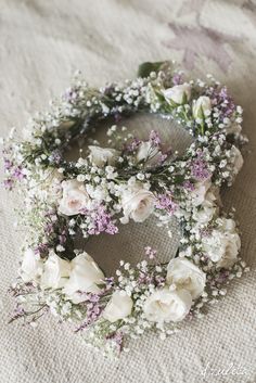 two wreaths with white flowers and baby's breath are on a tablecloth