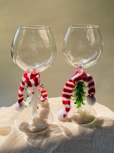 two wine glasses decorated with christmas decorations