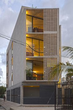 an apartment building with multiple levels and balconies on the second floor, is lit up at night