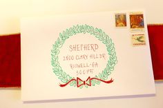 a white envelope with a red ribbon on it and a stamp that says sheherd