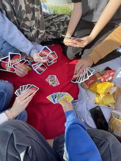 several people sitting around a table playing cards