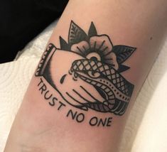 a black and white photo of a tattoo that says trust no one