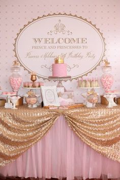 a pink and gold dessert table with cake