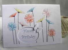 a happy birthday card with colorful fireworks on it and a ball of yarn in the background