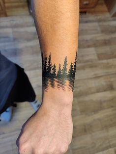 a person with a forest tattoo on their arm