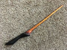 an old wooden stick laying on the floor next to a black handled mallet with wood handle