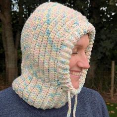 a woman wearing a crocheted hat with a hood on her head and the top part of her face covered in yarn