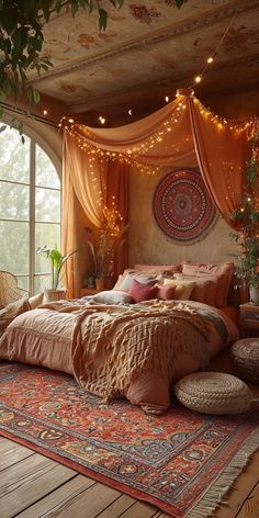 a large bed sitting under a window next to a wooden floor covered in pillows and blankets