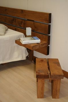 a bed with a wooden headboard and foot stools next to it on a hard wood floor