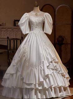 a white wedding dress on display in front of a fireplace