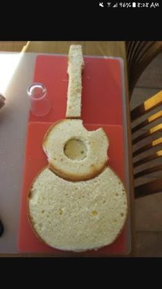 a piece of bread with a guitar shaped hole in the middle on a cutting board