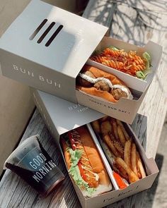 two boxes of food sitting on top of a wooden table