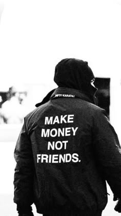 a man walking down the street wearing a jacket that says make money not friends on it